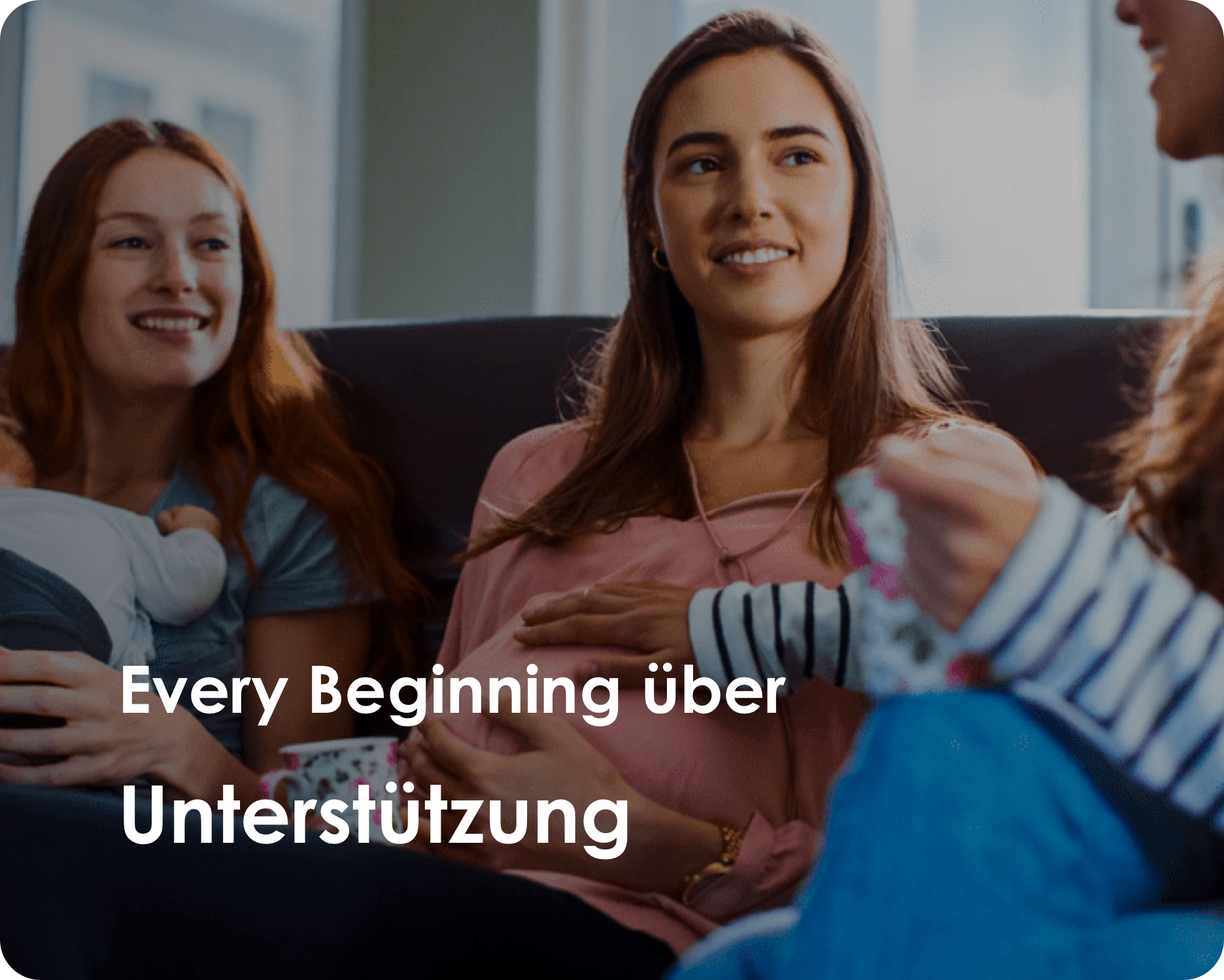 Drei Frauen sitzen nebeneinander, unterhalten sich und lachen.